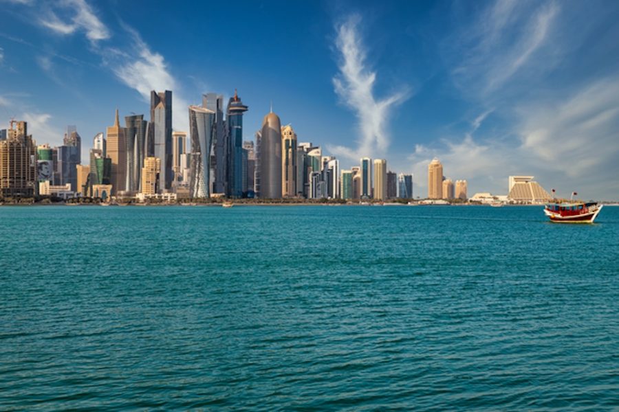 640-doha-qatar-skyline-daylight-view-with-clouds-in-the-sky-showing-skyscrapers-and-dhow-with-qatar-flag-in-background-and-arabic-gulf-in-foreground