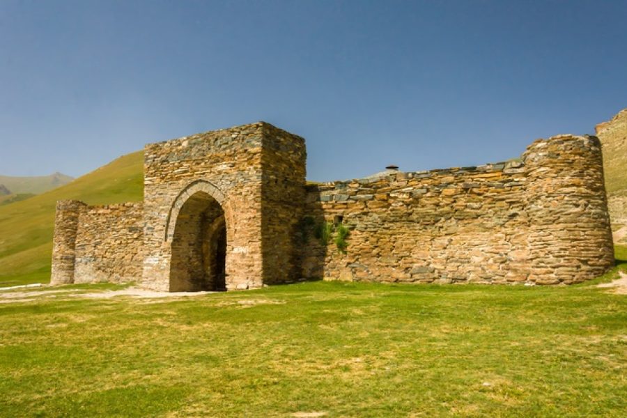 The Tash Rabat fortress, historic caravanserai, stout stone masonry and defensive arches in Kyrgyzstan's pastoral hills, its preserved edifice, the caravan culture of the Silk Road, Central Asian