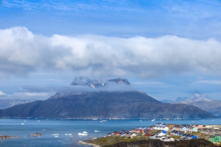 Typical architecture of Greenland capital Nuuk with colored houses located near fjords and icebergs.