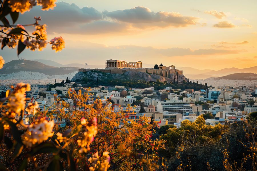 The acropolis of athens is bathed in the golden light of sunset, while colorful trees add vibrancy to the foreground